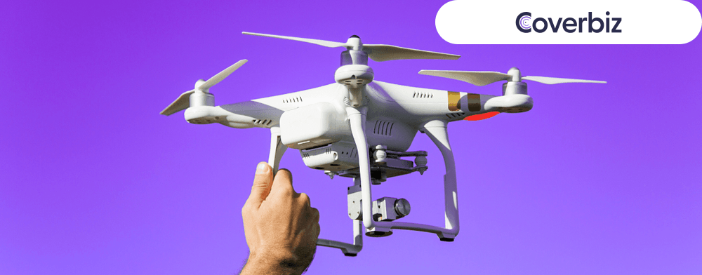 A hand holding a drone in a violet background