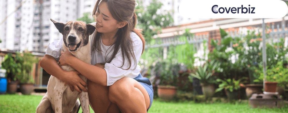 A young woman in casuals embracing her pet dog