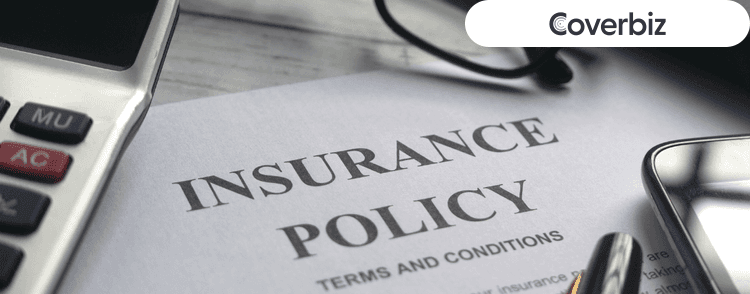 a paper with the name Insurance policy written on top, with a calculator and a spectacle visible partially